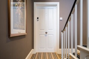 Enter room 1 through this door, featuring a modern handle and a framed picture on the adjacent wall.