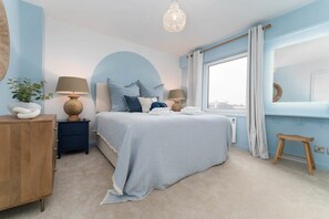 A bedroom with a bed, bedside tables, a window, and a view of the city. - Host & Stay | Sea View Marine Parade (Brighton and Hove)