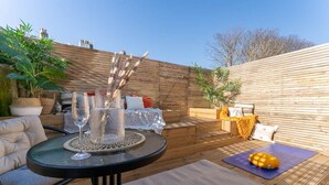 A patio with a round table, chairs, a yoga mat, and a decorative plant arrangement. - Host & Stay | Round Hill Apartment (Brighton and Hove)