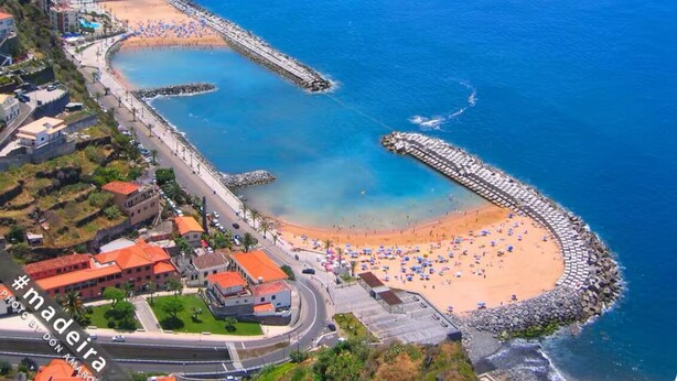An aerial view of a coastal area with a beach, a promenade, and a marina. - Calheta Ocean View Retreat - Casa Santana (Estreito da Calheta)