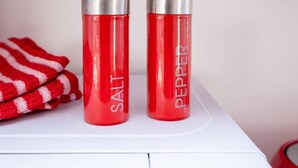 Two red containers labeled "SALT" and "PEPPER" on a white surface. - Host & Stay | Wilson Studio (Brighton and Hove)