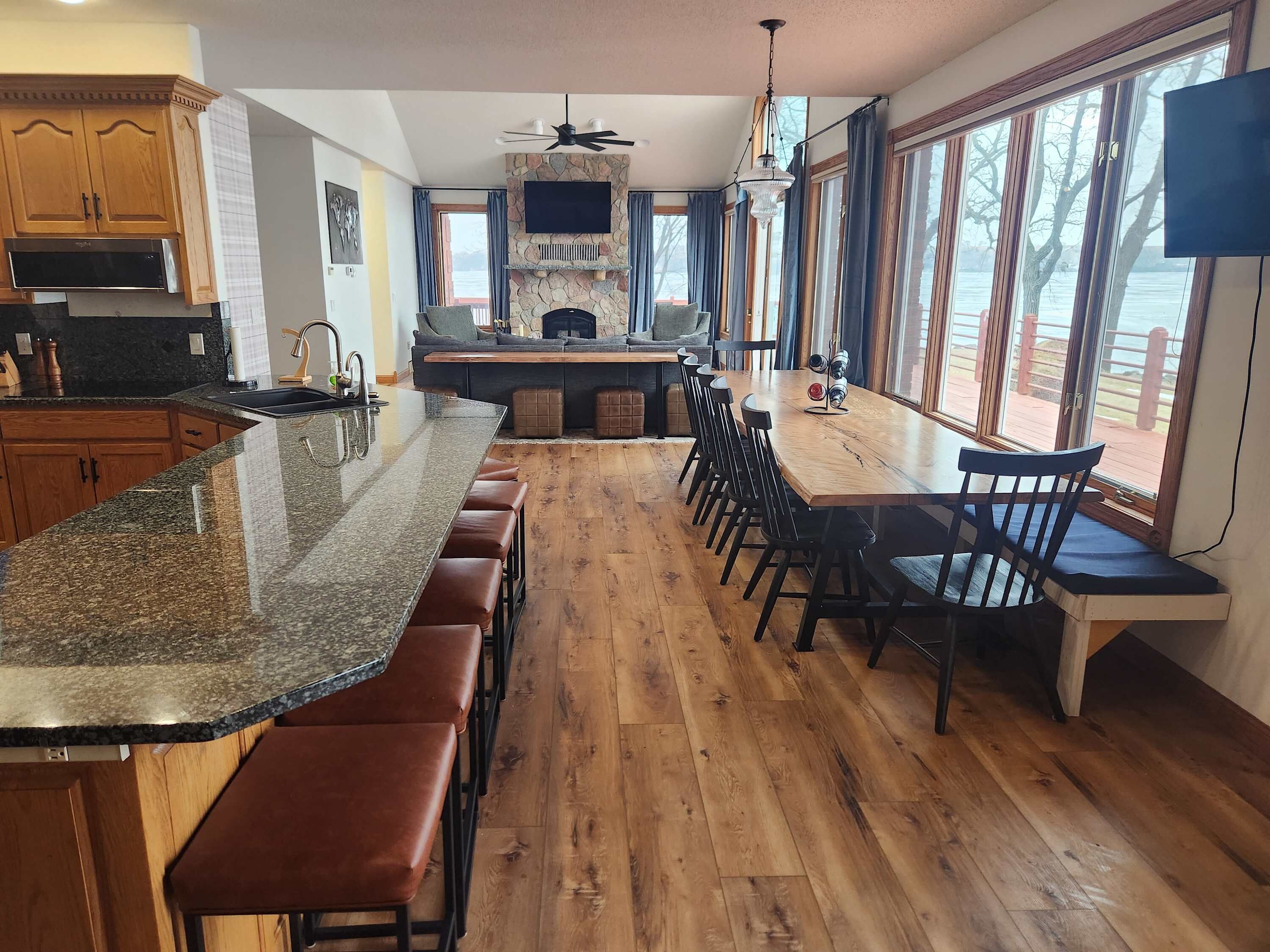 Una cocina amplia con encimera de granito, armarios de madera y una isla grande con taburetes de bar.