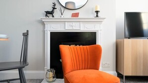 A living room with a fireplace, a television, and a dining area. - Host & Stay | Portland Apartment (Brighton and Hove)
