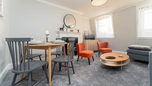 Una sala de estar moderna con una mesa de comedor, sillas, un sofá y una mesa de centro.