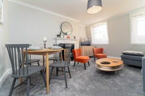 Ein modernes Wohnzimmer mit Esstisch, Stühlen, einer Couch und einem Couchtisch.