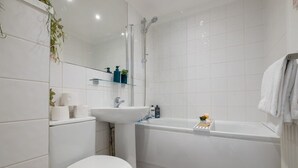 Un baño moderno con inodoro, lavamanos y bañera.