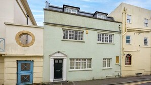 A two-story building with a light green facade, a black door, and a small porch. - Host & Stay | Sillwood Seafront (Brighton and Hove)