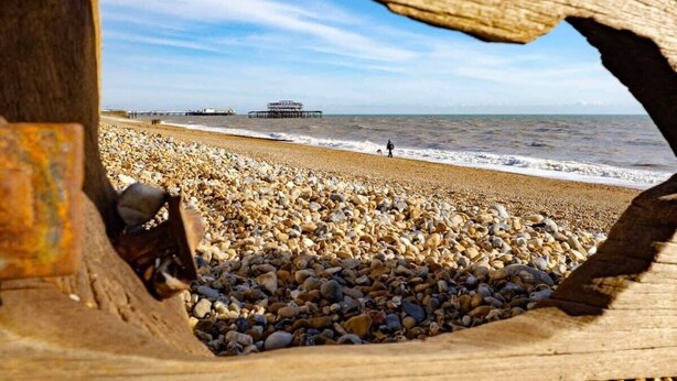 A beach with pebbles and a pier in the distance. - Host & Stay | Montpelier Colours (Brighton and Hove)