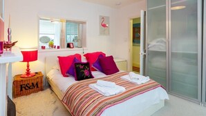 A bedroom with a bed, a bedside table, a lamp, a window, and a wardrobe. - Host & Stay | Montpelier Colours (Brighton and Hove)