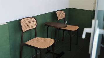 Two chairs and a table in a corner with green and white walls.