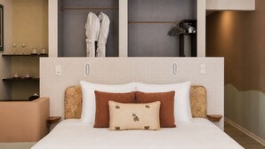 A neatly made bed with a white headboard, two brown pillows, and a floral-patterned pillow. - Le Macaron Garden Stay - Boutique Hotel Da Lat (Cam Ly - Da Lat)