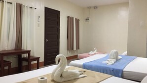 Une chambre d’hôtel avec deux lits, un bureau et une porte de salle de bain.
