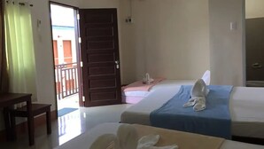 Une chambre d’hôtel avec deux lits, un bureau et une chaise.