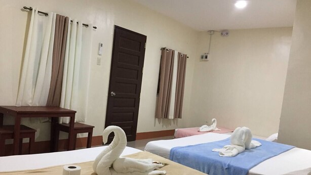 Une chambre d’hôtel avec deux lits, un bureau et une porte.