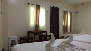 Une chambre d’hôtel avec deux lits, une petite table, une chaise et un bureau.