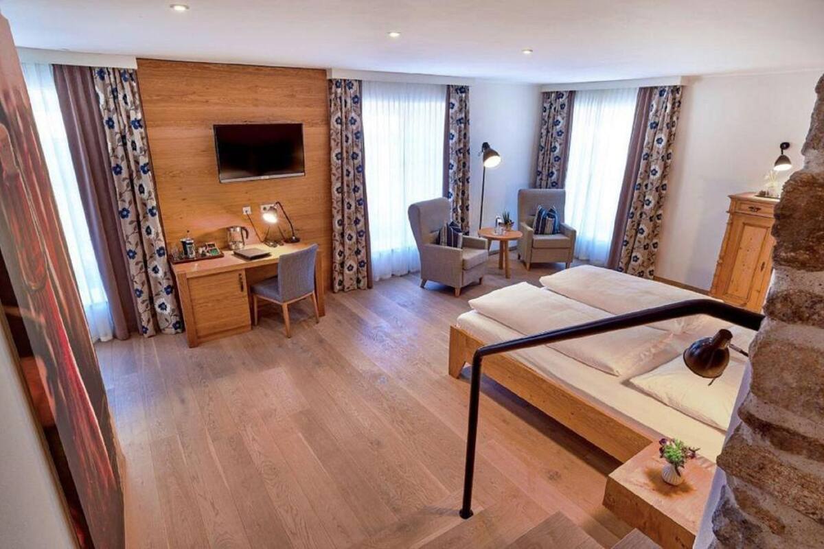 Una habitación de hotel con cama, escritorio, silla y televisión.