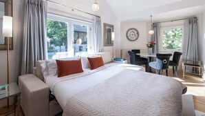 Una moderna camera d'hotel con un letto grande, una scrivania e due sedie.