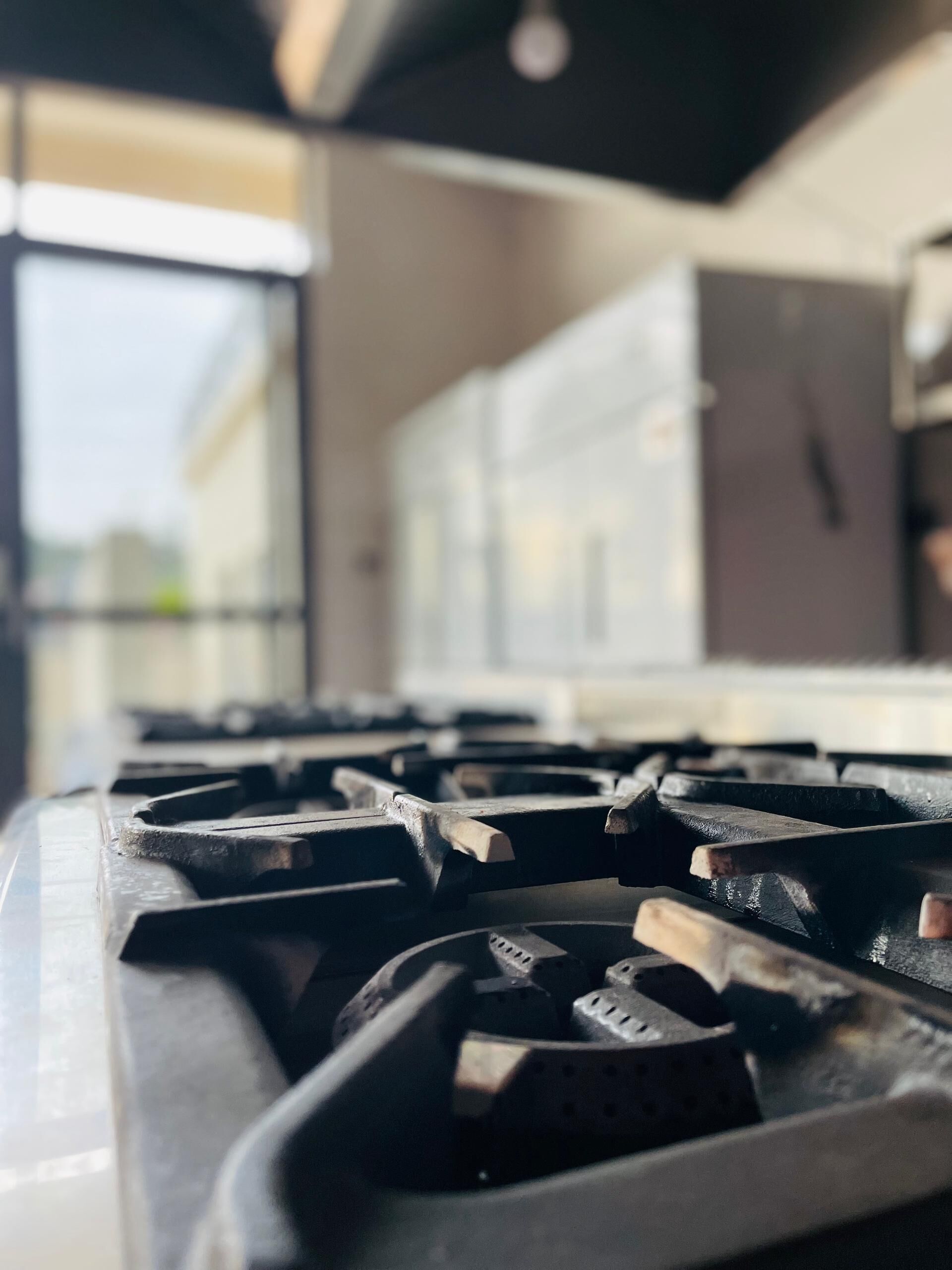Primer plano de una estufa de cocina con diseño moderno, que cuenta con múltiples quemadores y un panel de control.
