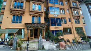Un hotel a più piani con uno stile architettonico tradizionale, caratterizzato da balconi e ampie finestre.