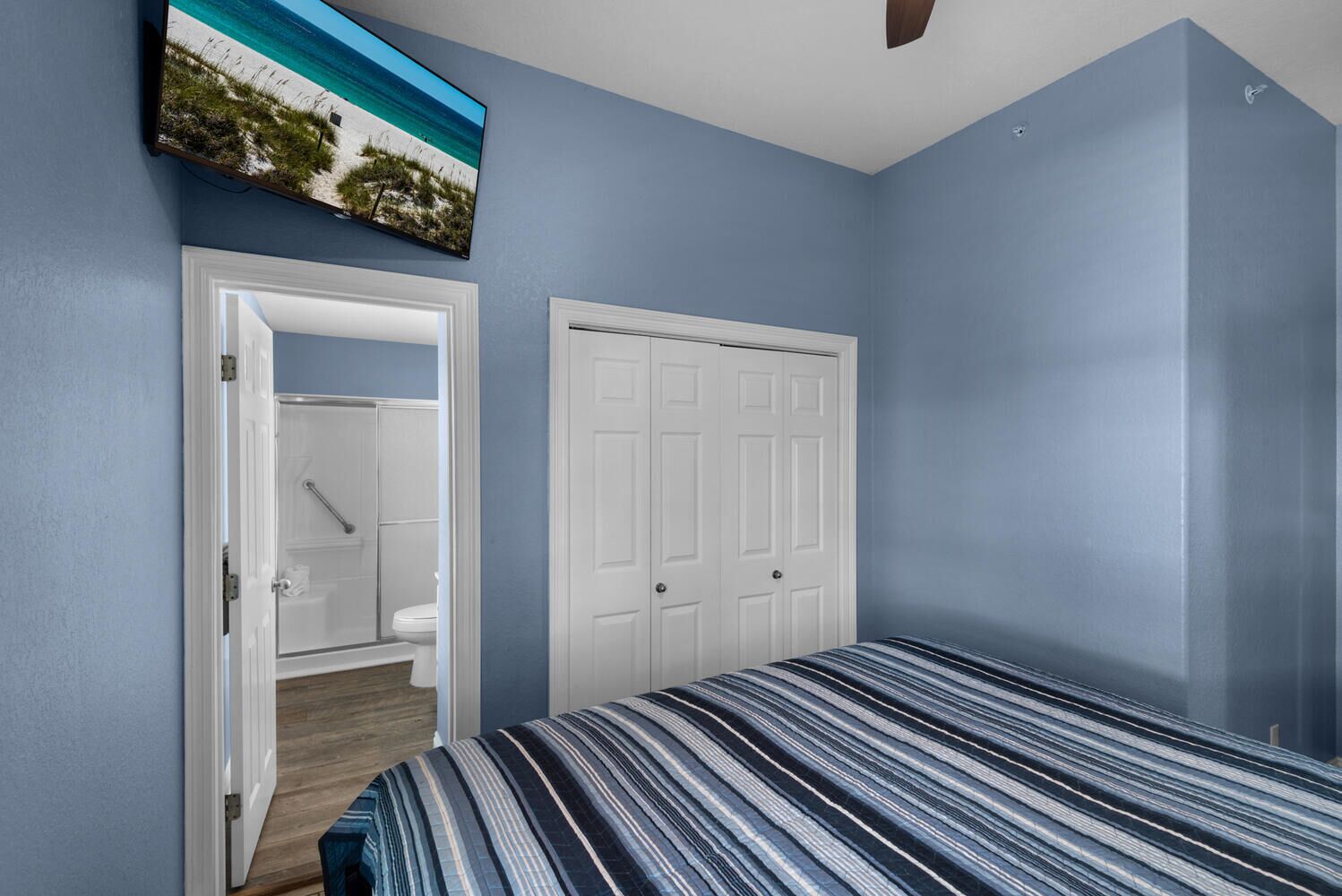 A bedroom with a bed, a closet, and a bathroom visible through an open door.