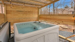 A wooden hot tub with a clear water surface, surrounded by a wooden deck and a metal roof. - Beautiful Poconos Getaway with Game room ,Hot Tub, and Fire pit (Tobyhanna)