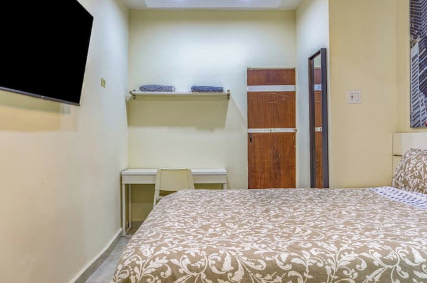 Une petite chambre à coucher avec un lit, un bureau et une armoire.