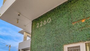 Fachada de edificio con un muro verde y el número 2260.