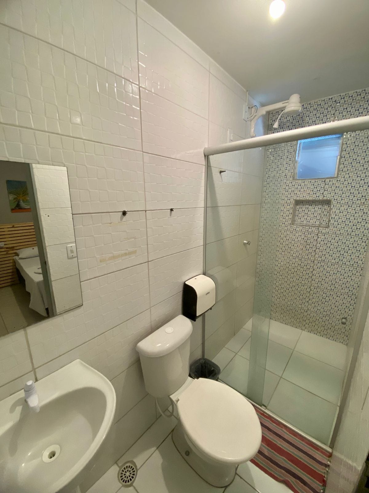 Un baño con inodoro, bidé y zona de ducha con mampara de vidrio.
