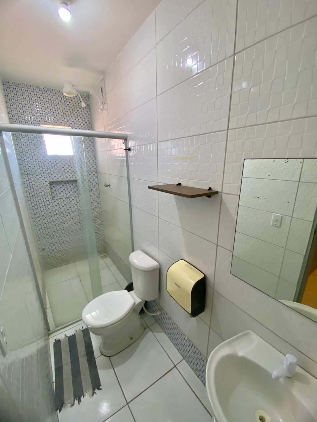 A bathroom with a toilet, a sink, and a shower area.