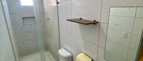 A bathroom with a toilet, a sink, and a shower area.