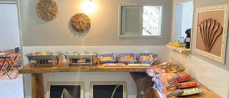 A kitchen with a wooden countertop, buffet setup, and decorative wall art.