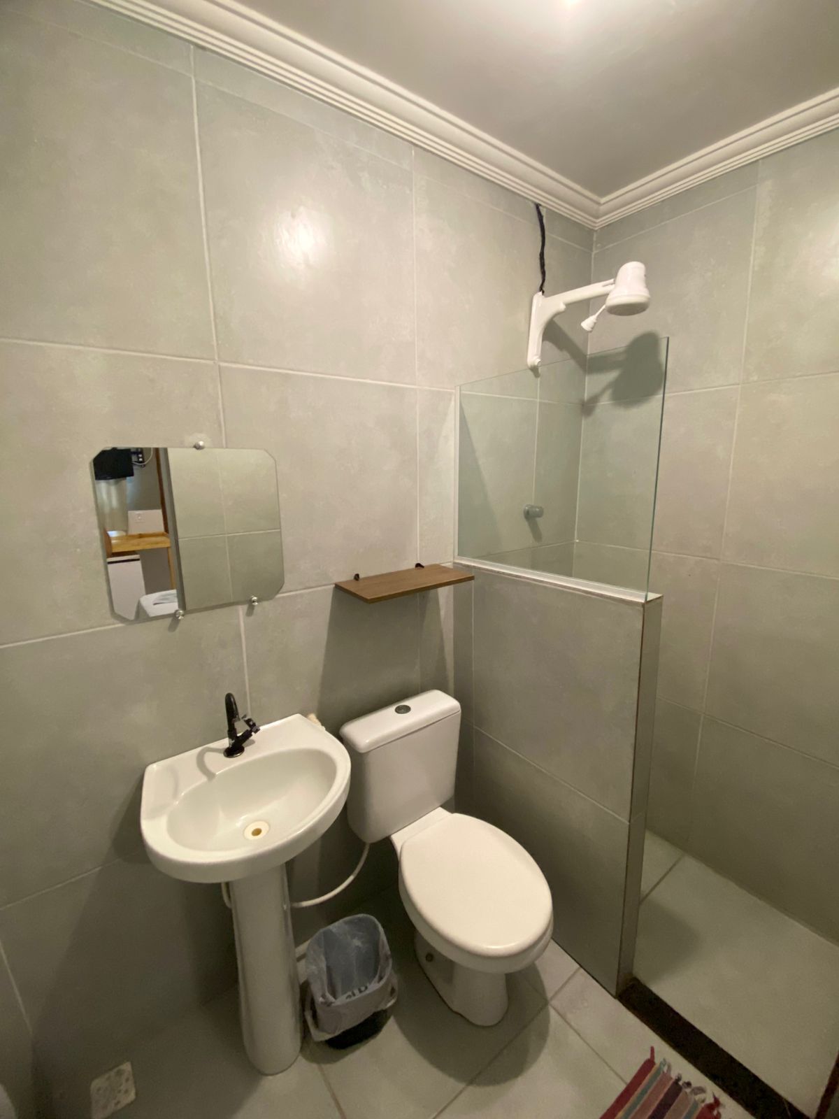 Un bagno con lavandino, WC e cabina doccia in vetro.
