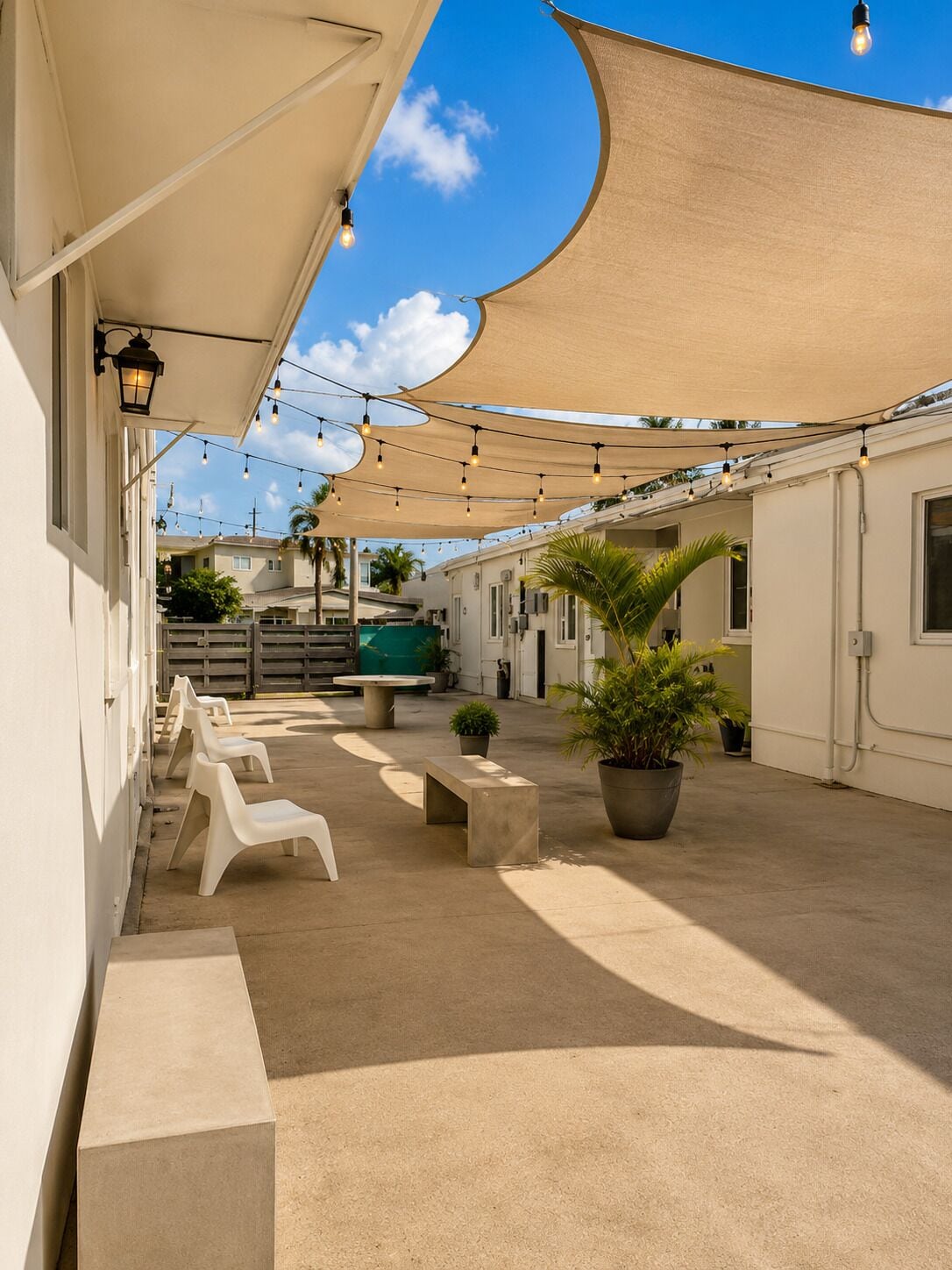 An outdoor patio area with string lights, seating, and potted plants.