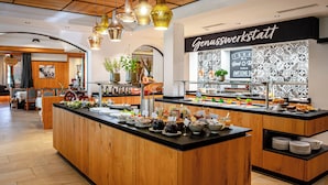 A breakfast bar with a variety of food items and a sign that reads "Genusswerkstatt". - Hotel Barbarahof (Saalbach-Hinterglemm)