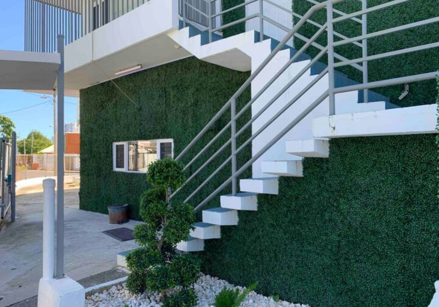Ein modernes Gebäude mit einer grünen Wand und einer weißen Treppe.