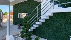 Un bâtiment moderne doté d’un mur végétal et d’un escalier blanc.