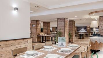 A restaurant with wooden panel walls, tables set with plates and glasses, and a sign indicating a holiday partnership.
