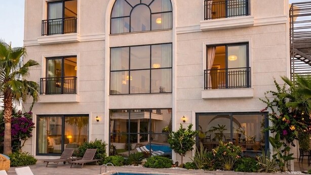 Ett hotell med en swimmingpool, solstolar och en skylt med texten ”PACIS”.
