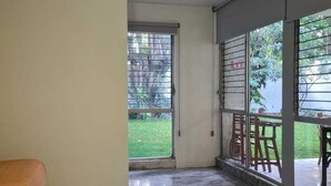 A room with a bed, a large sliding glass door leading to a balcony, and a marble floor. - Estancia monraz (Guadalajara)