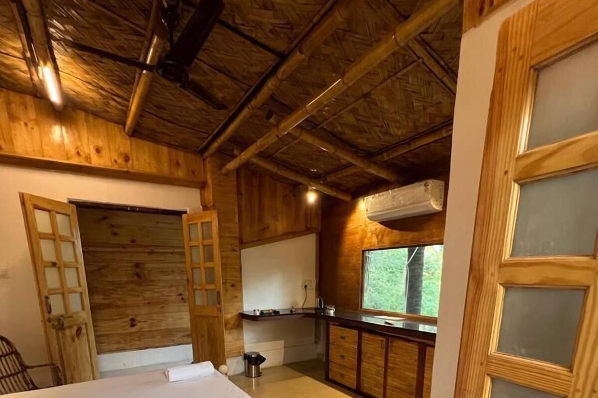 Un interior de madera con una cama, kitchenette y una ventana.