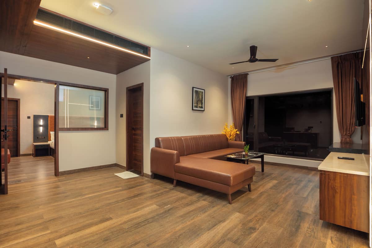 A modern living room with a brown leather sofa, a coffee table, and a fireplace.
