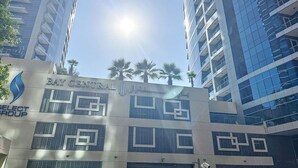 A multi-story building with the sign "Bay Central Hotel" and "Select Group" logos. - Bay Central West - Spacious Studio in the Dubai Marina (Dubai Marina)