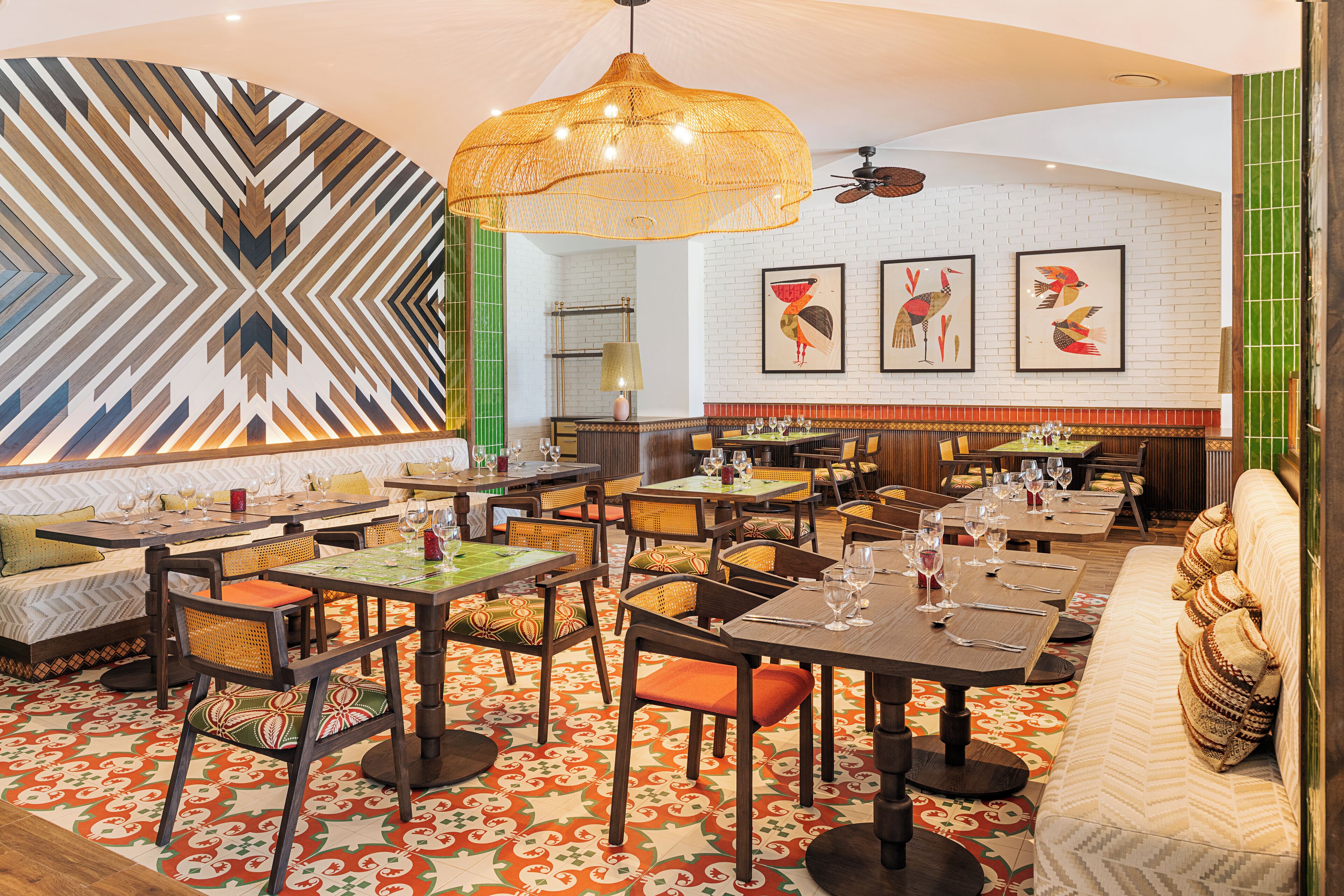 Un restaurante con varias zonas de comedor, mesas y sillas, y un suelo con diseño.