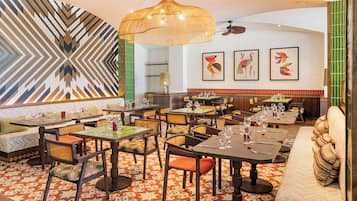 Un restaurante con varias zonas de comedor, mesas y sillas, y un suelo con diseño.