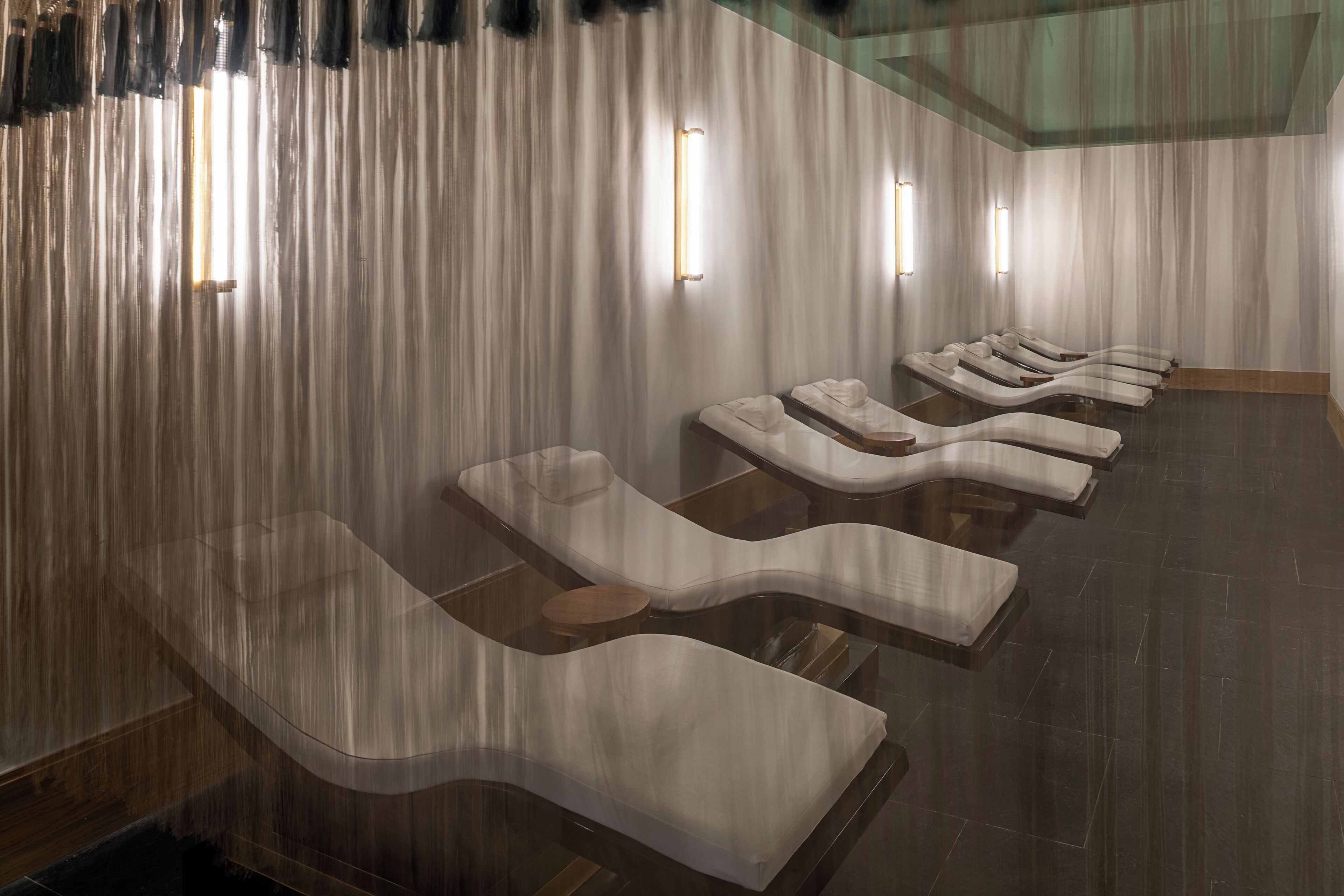 A spa room with reclining chairs and a wooden floor.