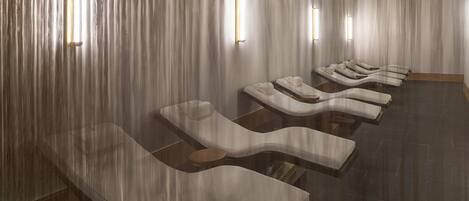 A spa room with reclining chairs and a wooden floor.