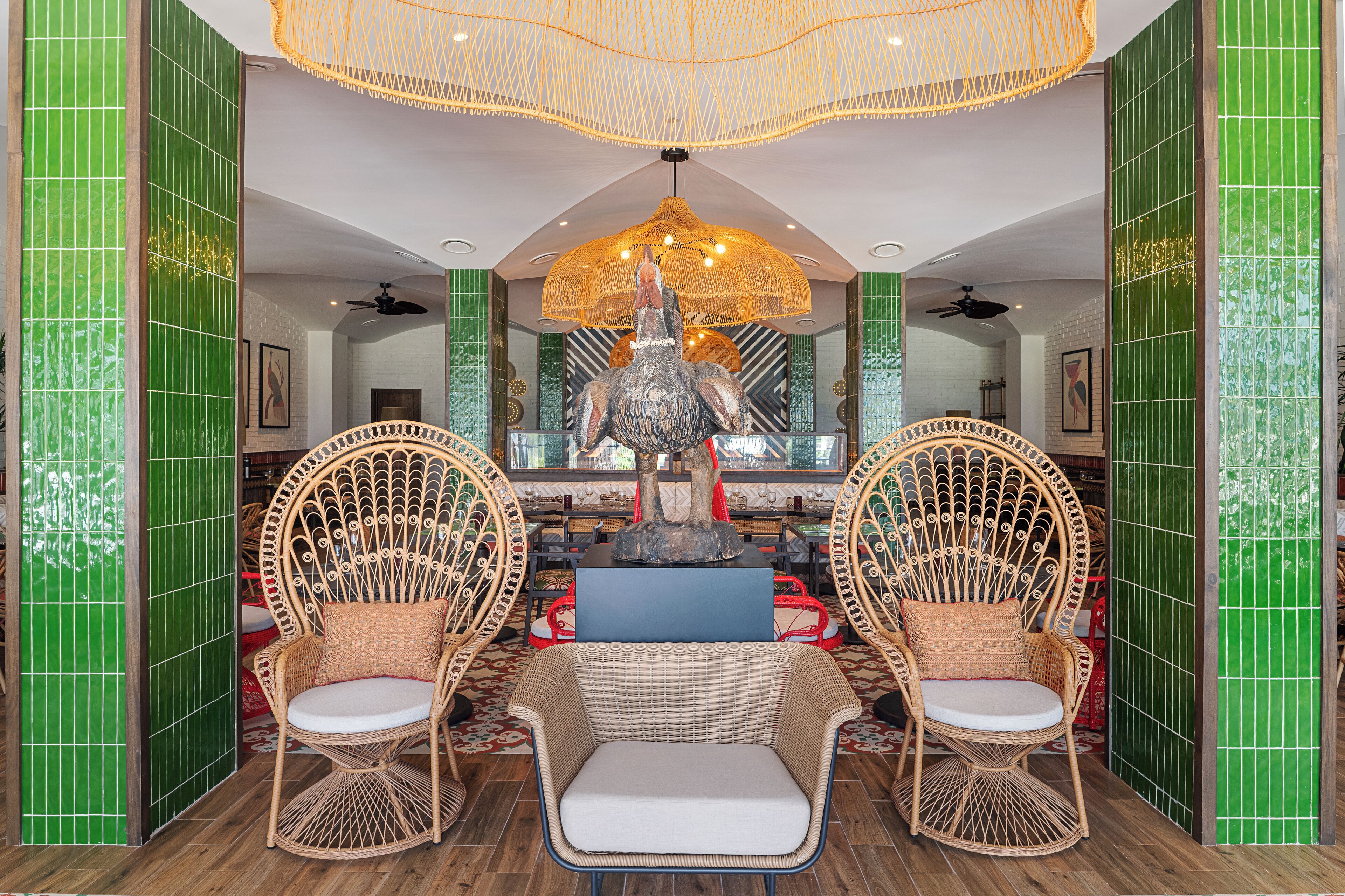 Un vestíbulo con sillones de mimbre, una mesa central y una fuente decorativa.