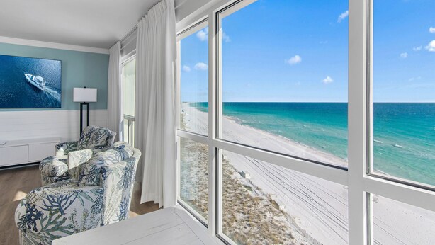 A room with a large window offering a view of a beach and ocean. - 🌅 Gulf Front + Seasonal Comp Beach Setup | Shoreline 1081 - Stunning Views (Destin)