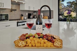 A kitchen counter with a charcuterie board, two glasses of red wine, and a bottle labeled "Josh." - Serene Guadalupe Getaway-River Access Nearby! (Spring Branch)