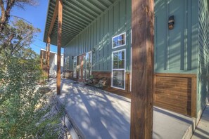 A covered porch with wooden beams, a concrete floor, and a window with a white frame. - Serene Guadalupe Getaway-River Access Nearby! (Spring Branch)